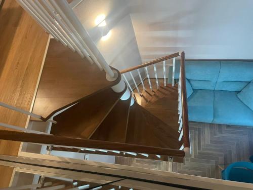 a spiral staircase in a room with a blue couch at Palazzo Sarti Suites in Rodi Garganico