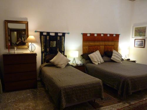 ローマにあるApartment Vatican Vistaのベッド2台と鏡が備わるホテルルームです。