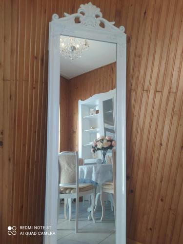 einen Spiegel im Esszimmer mit einem Tisch und Stühlen in der Unterkunft Villa Vanília in Keszthely