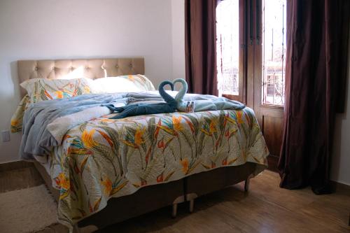 a bed with a blanket with a pair of scissors on it at Pouso Primavera in Tiradentes