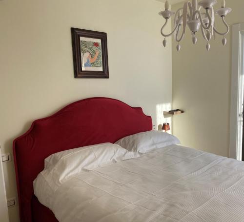 a bed with a red headboard and white sheets at B&B Il Melograno in Fano
