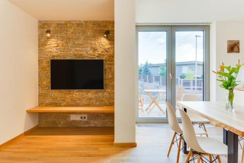 a living room with a television on a brick wall at Tilia apartments Březová in Březová