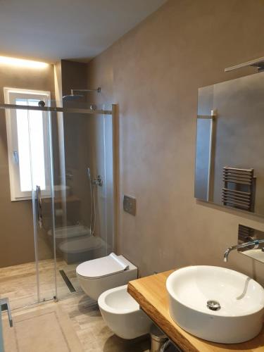 a bathroom with a sink and a toilet and a shower at Hotel Ollastu in Costa Corallina