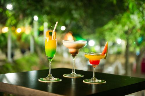 three different cocktails sitting on a table at Wet Water Airport Resort in Gampaha