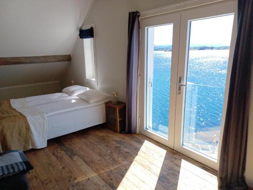 a bedroom with a bed and a large window at Sveggvika Guesthouse in Averoy