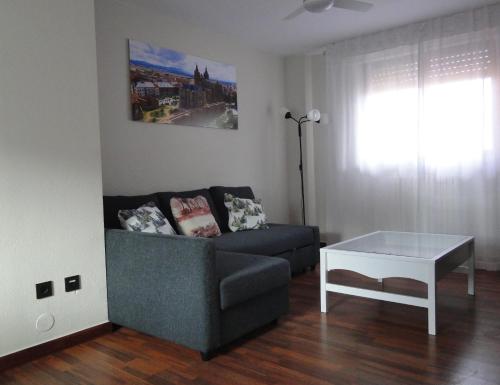 een woonkamer met een bank en een tafel bij INSULA PLAzA MAYOR ATICO in Astorga