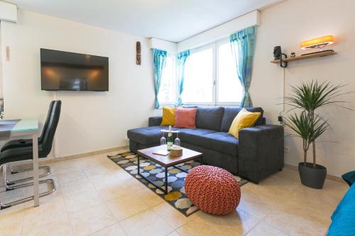 una sala de estar con un sofá y una mesa en Spirit Apartments - Studio 1 und 2 - Küche - Parkplatz, en Engelberg