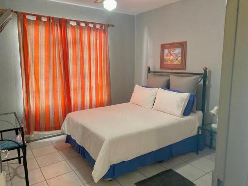 a bedroom with a bed with an orange curtain at Bela-Bela Pendleberry Grove Unit 3 in Bela-Bela