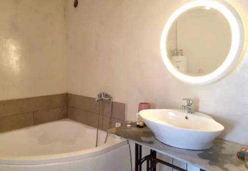 Un baño con lavabo, bañera y espejo. en Cozy nest, en Áfissos