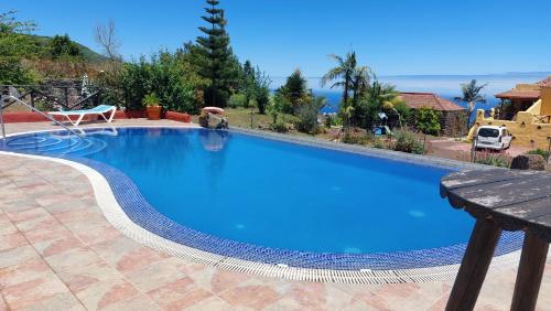 a large pool with blue water in a yard at Casonas de Marengo in Icod de los Vinos