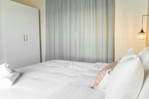 a white bed in a room with a window at Tradewinds Apartments Simpson Bay in Simpson Bay