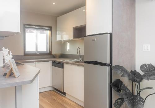 a kitchen with white cabinets and a refrigerator at Tradewinds Apartments Simpson Bay in Simpson Bay