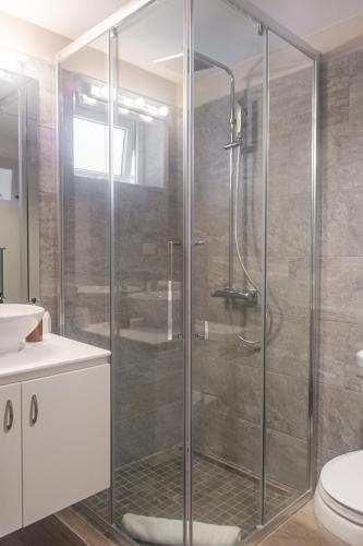 a glass shower in a bathroom with a toilet at Tradewinds Apartments Simpson Bay in Simpson Bay