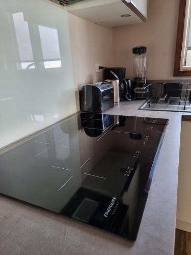 a kitchen with a glass counter top with a microwave at Tradewinds Apartments Simpson Bay in Simpson Bay