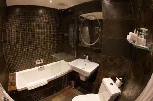 ein Badezimmer mit einem Waschbecken, einer Badewanne und einem WC in der Unterkunft Best Western Plus Centurion Hotel in Midsomer Norton