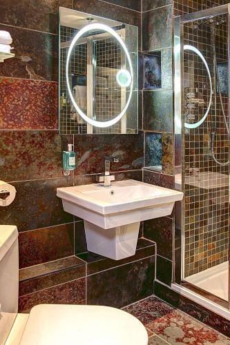 a bathroom with a sink and a toilet and a mirror at Best Western Plus Centurion Hotel in Midsomer Norton