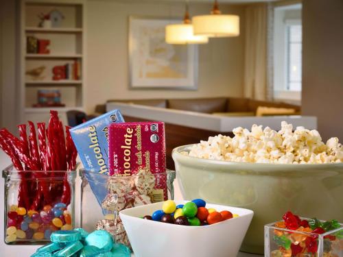 a table with popcorn and candy and bowls of popcorn at Sonesta ES Suites Houston Galleria in Houston