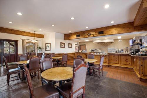 Un restaurante con mesas y sillas y un mostrador. en Best Western Corona Hotel & Suites, en Corona