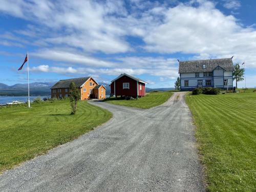 a dirt road in front of a house and a flag at Sandtorgholmen Hotel - Best Western Signature Collection in Harstad