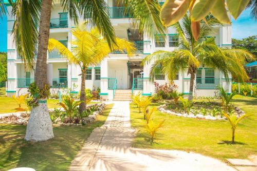 a building with palm trees in front of it at Best Western Grand Baymen Gardens in San Pedro
