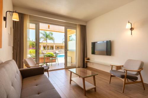 a living room with a couch and a tv at Vila Luz in Luz