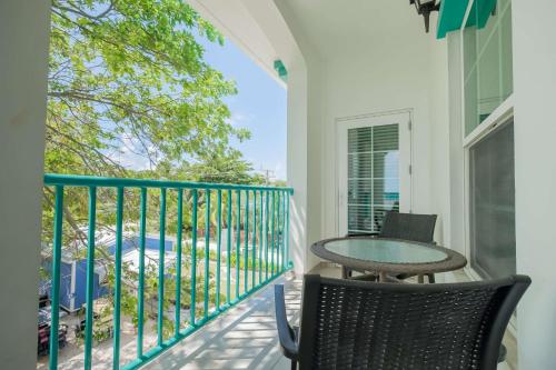 a balcony with a table and chairs and a pool at Best Western Grand Baymen Gardens in San Pedro