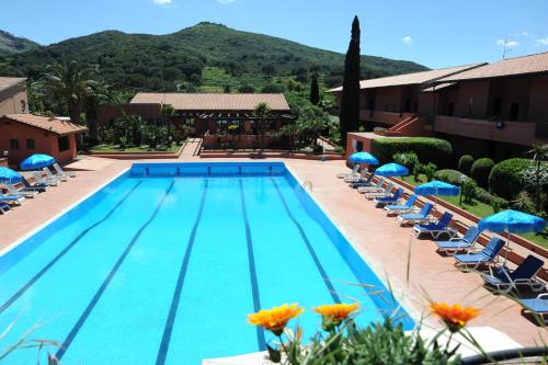 a large swimming pool with chairs and umbrellas at Hotel Residence Villa San Giovanni in Portoferraio