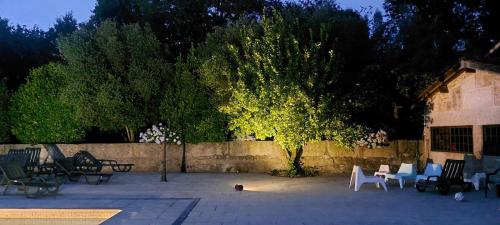 a group of chairs and a tree in a courtyard at Quinta do Carvalho - Nature Guest Houses in Guimarães