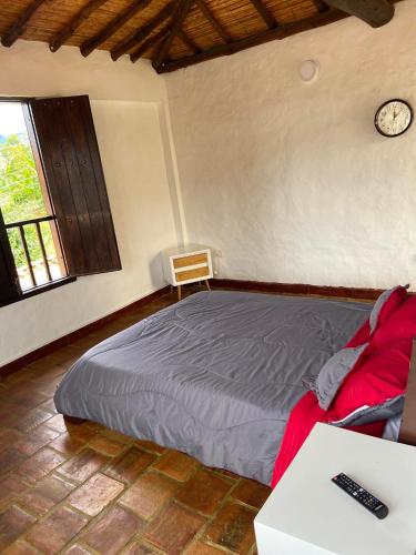 a bedroom with a bed and a clock on the wall at Casa Hostal Bellavista in Zapatoca