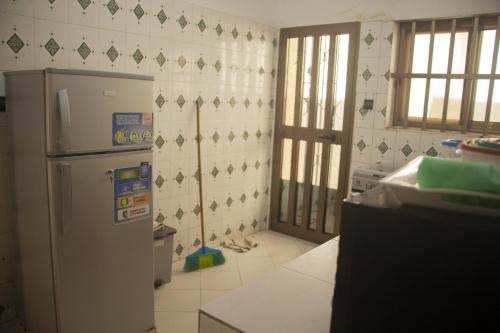 a kitchen with a white refrigerator in a room at Résidence Le Cador II à Cotonou in Cotonou