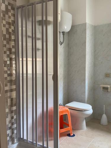 La salle de bains est pourvue de toilettes et d'une porte de douche en verre. dans l'établissement Casa vacanze CoMì, à Santa Maria del Cedro
