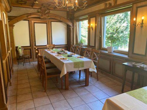 ein Esszimmer mit einem Tisch und einigen Fenstern in der Unterkunft Hotel-Garni Domblick in Bad Honnef am Rhein