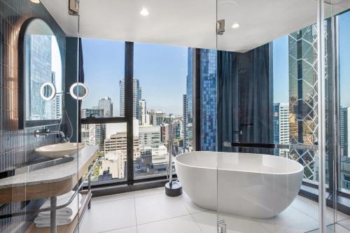 墨尔本voco Melbourne Central的带浴缸和大窗户的浴室