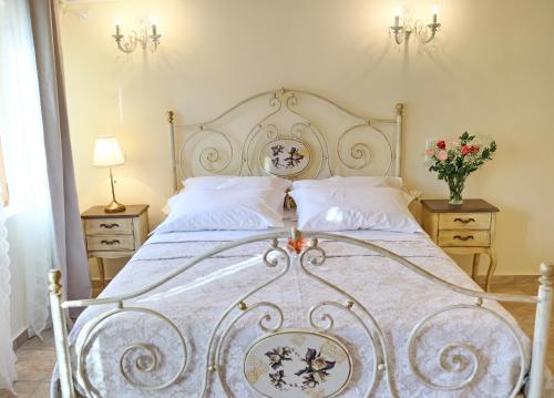 a bedroom with a large white bed with flowers on it at Castellmare in Nafpaktos