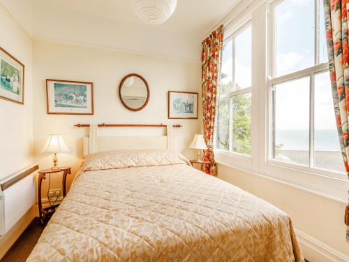 a bedroom with a bed and two windows at Clooneavin Apartment 3 in Lynmouth
