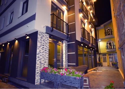 un cortile di un edificio con panchina e fiori di Comfort Hotel a Struga