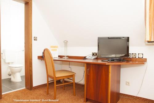 a desk with a computer and a chair at Hotel Bienefeld in Korschenbroich