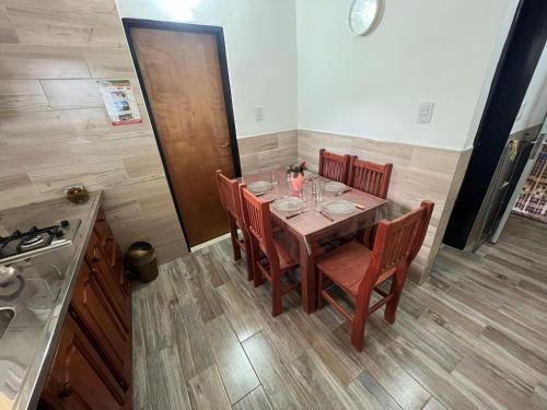 a dining room with a table with chairs and a kitchen at El Ámbar in Colón