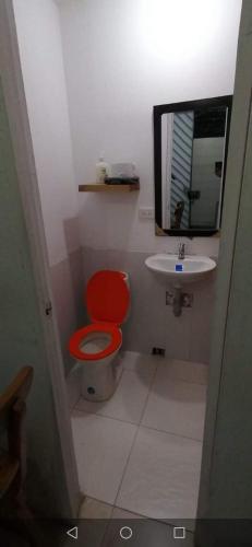 a bathroom with a red toilet and a sink at Parrot House San Antonio in Cali