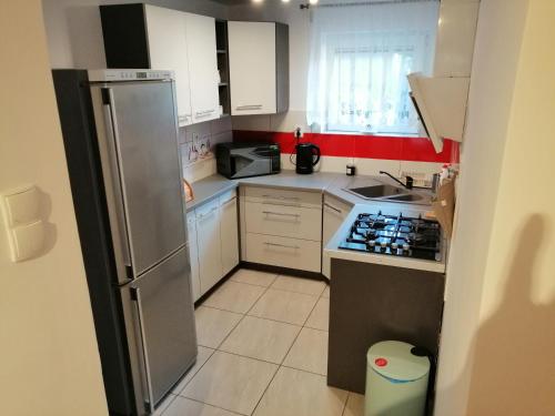 マルボルクにあるApartament Przy Parkuの小さなキッチン(白いキャビネット、冷蔵庫付)