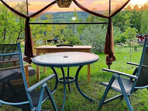 a table and two chairs in the grass with a table at 4 person holiday home in UNDEN S in Undenäs