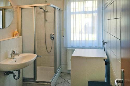 uma casa de banho com um chuveiro e um lavatório. em Apartment, Fedderwardersiel em Fedderwardersiel