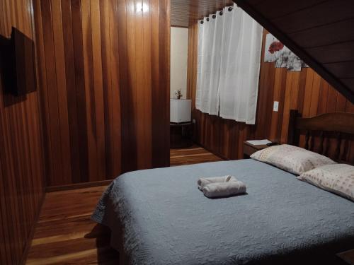 a bedroom with a bed with a white towel on it at Casa do Trem Suítes in Campos do Jordão