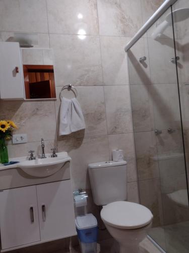 a bathroom with a toilet and a sink and a shower at Casa do Trem Suítes in Campos do Jordão