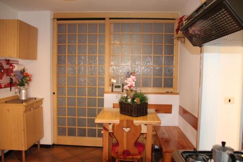 a kitchen with a table and a large glass door at Dolomites Holidays in Selva di Cadore