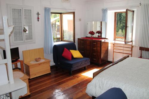 1 dormitorio con cama, silla y espejo en Dolomites Holidays, en Selva di Cadore