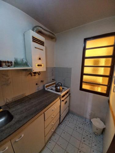cocina pequeña con fregadero y fogones en Edificio Trebol - Departamento en pleno centro de Carlos Paz en Villa Carlos Paz