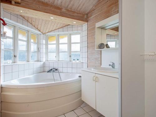 ein Badezimmer mit einer Badewanne und einem Waschbecken in der Unterkunft 6 person holiday home in Slagelse in Slagelse