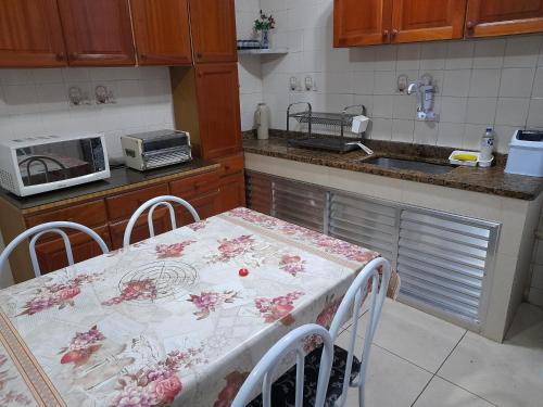 a kitchen with a table with a table cloth on it at CASA 3 MIN a PÉ da PRAIA DO FORTE - CHURRASQUEIRA - WI FI in Cabo Frio