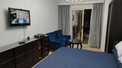um quarto de hotel com uma cama e uma televisão na parede em Florenza khamseen resort em Hurghada